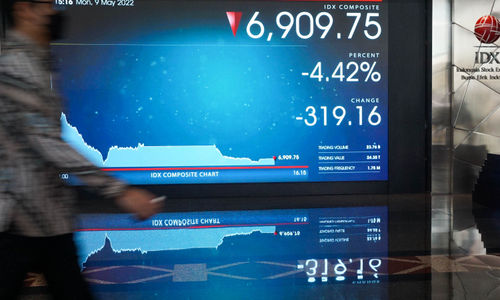 Karyawan melintas di depan layar pergerakan indeks harga saham gabungan (IHSG) di gedung Bursa Efek Indonesia (BEI) Jakarta, Senin, 9 Mei 2022. Foto: Ismail Pohan/TrenAsia