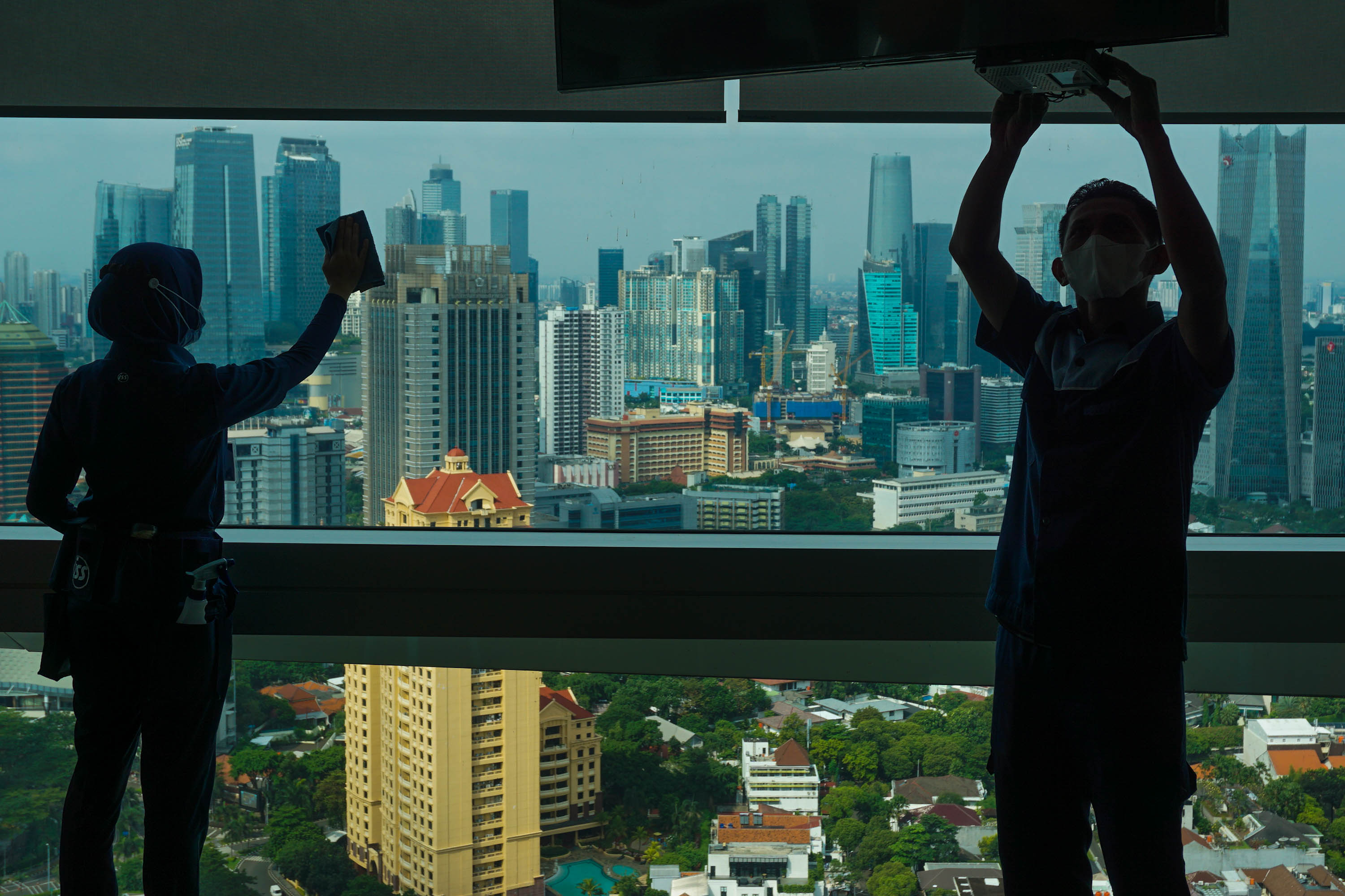 Pekerja beraktifitas dengan latar gedung perkantoran di Jakarta, Selasa, 10 Mei 2022. Foto: Ismail Pohan/TrenAsia