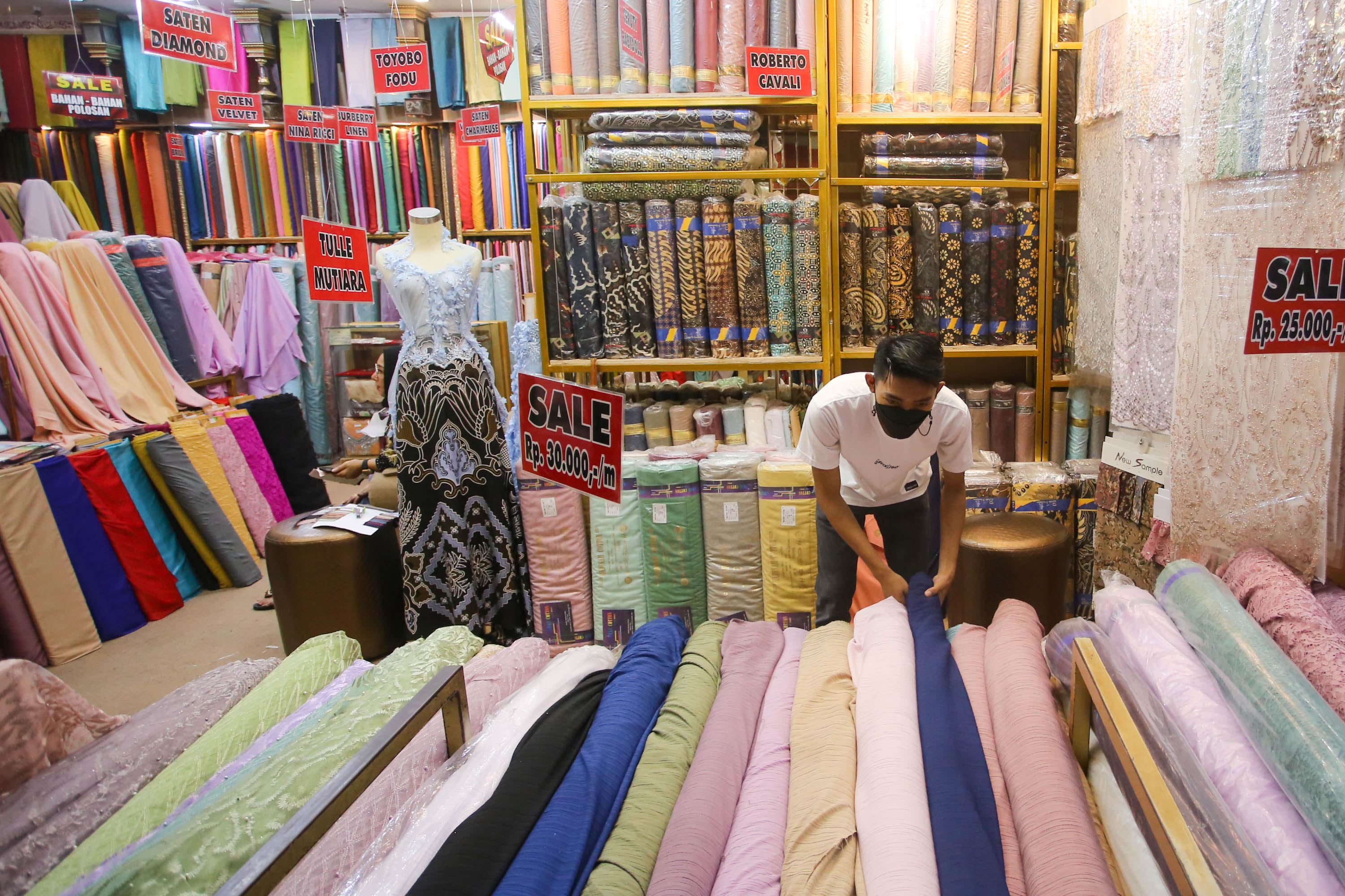 Pedagang menata kain bahan di kiosnya pusat grosir tekstil Pasar Tanah Abang, Jakarta, Jum'at, 20 Mei 2022. Foto: Ismail Pohan/TrenAsia