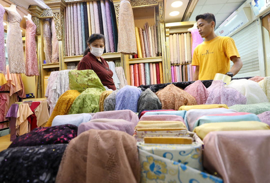 Pedagang melayani calon pembeli di kiosnya pusat grosir tekstil Pasar Tanah Abang, Jakarta, Jum'at, 20 Mei 2022. Foto: Ismail Pohan/TrenAsia