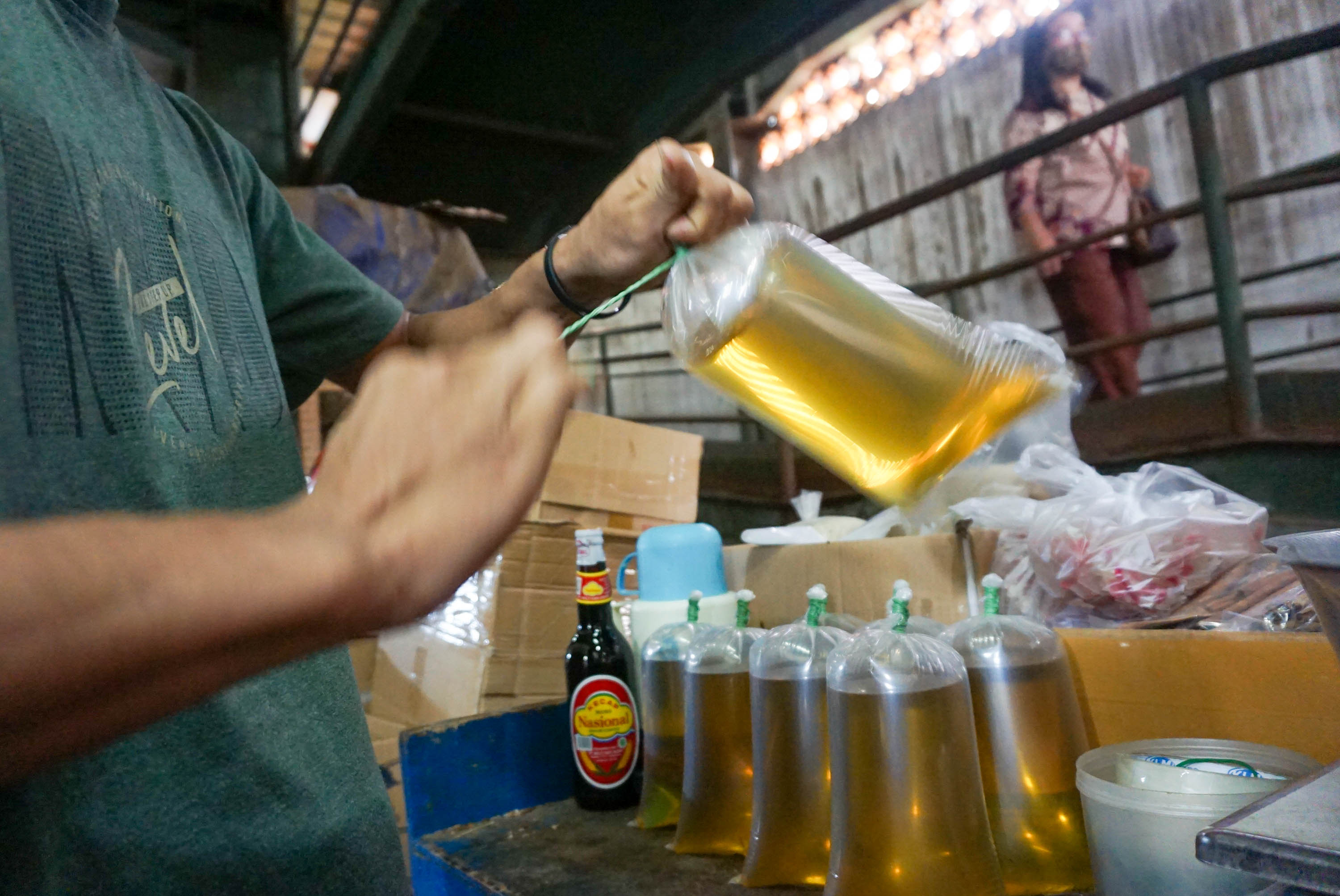 Pekerja mengemas minyak goreng curah di kios Pasar Senen, Jakarta. Foto: Kementerian Perdagangan (Kemendag) menargetkan untuk segera memasarkan Minyak goreng kemasan sederhana dengan merek 'Minyakita'.  Foto Ismail Pohan
