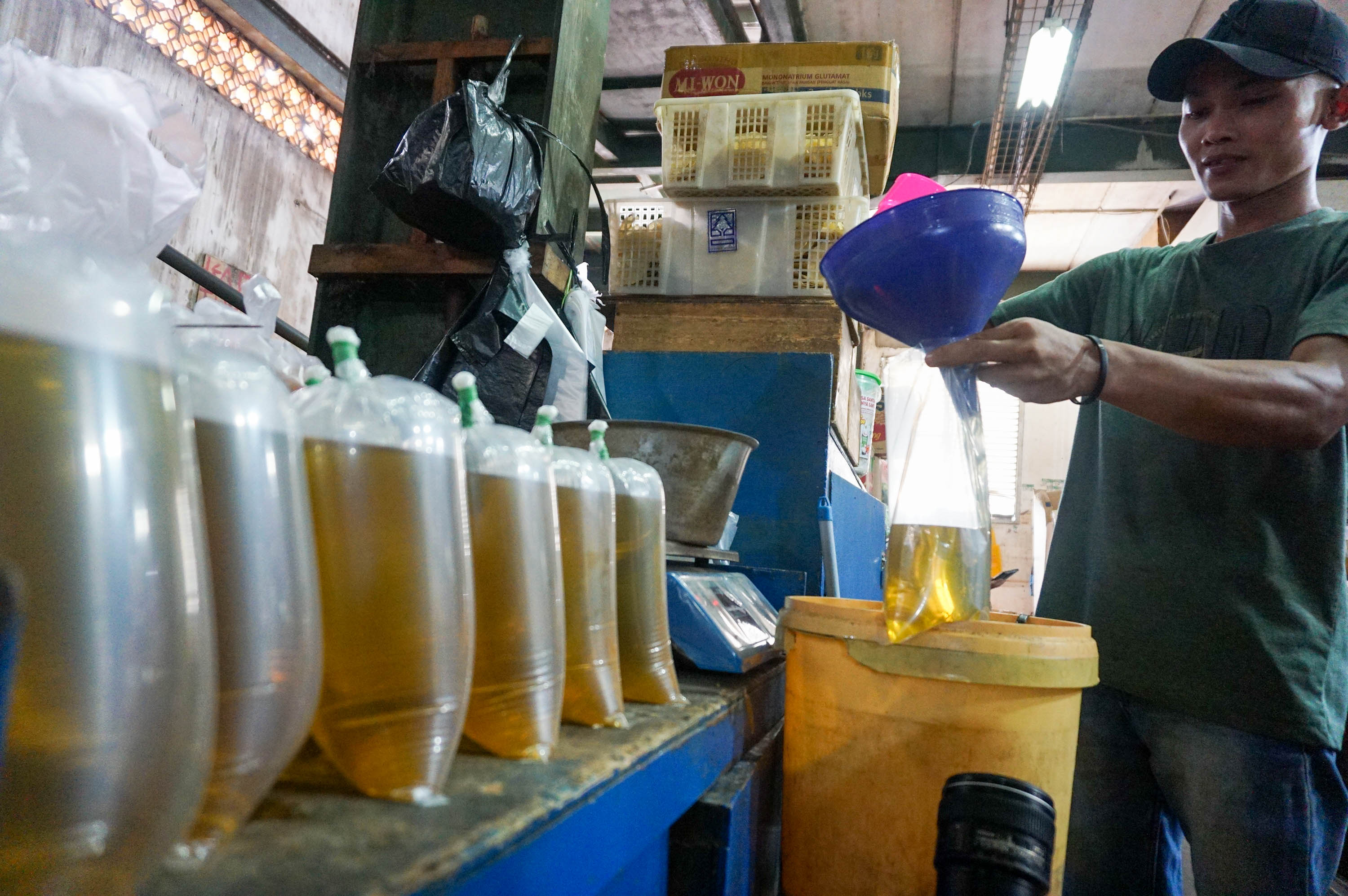 Pekerja mengemas minyak goreng curah di kios Pasar Senen, Jakarta. Foto: Ismail Pohan/TrenAsia
