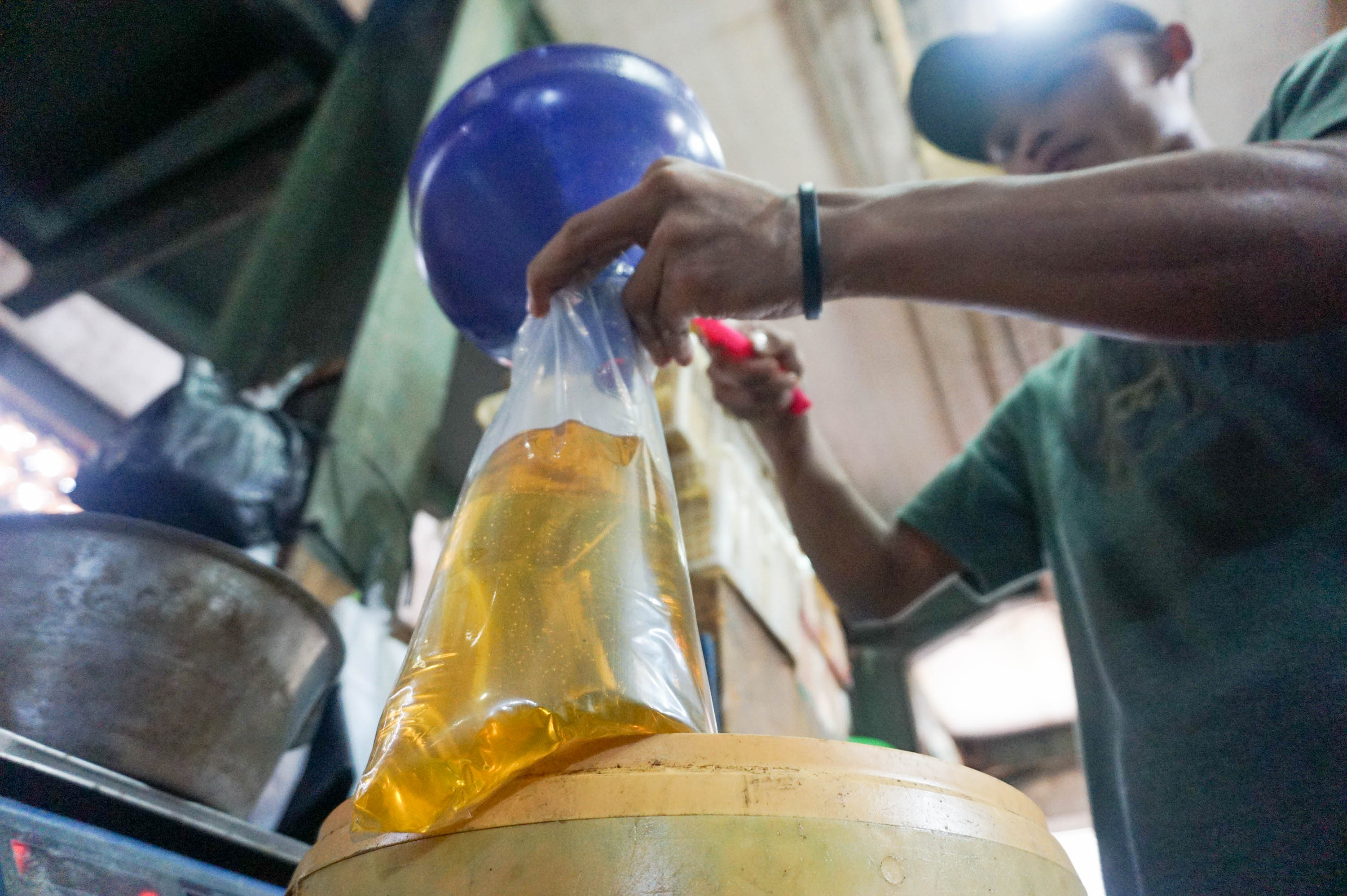 Pekerja mengemas minyak goreng curah di kios Pasar Senen, Jakarta. Foto: Ismail Pohan/TrenAsia