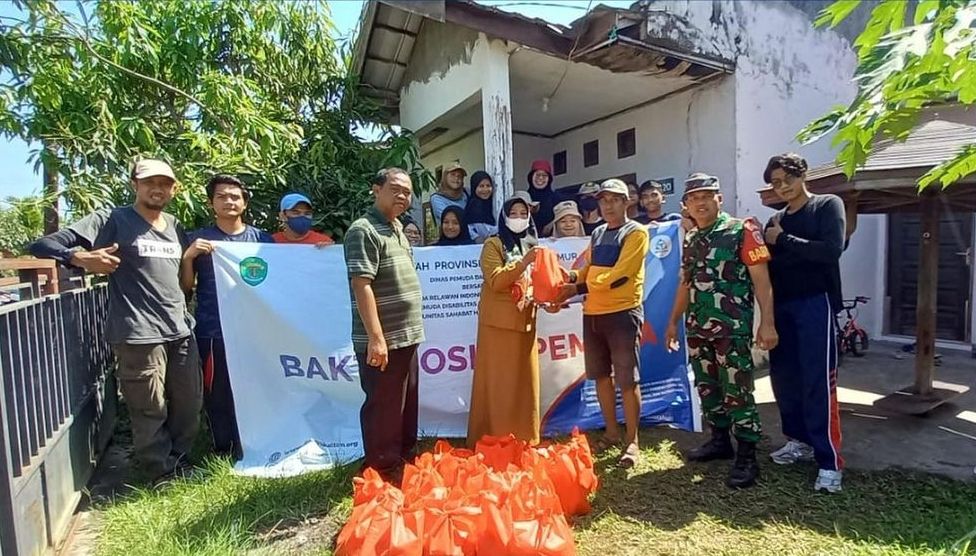 Peserta Kemah Pemuda Kaltim memberikan bantuan kepada warga kurang mampu di Kecamatan Samboja, Kutai Kartanegara.