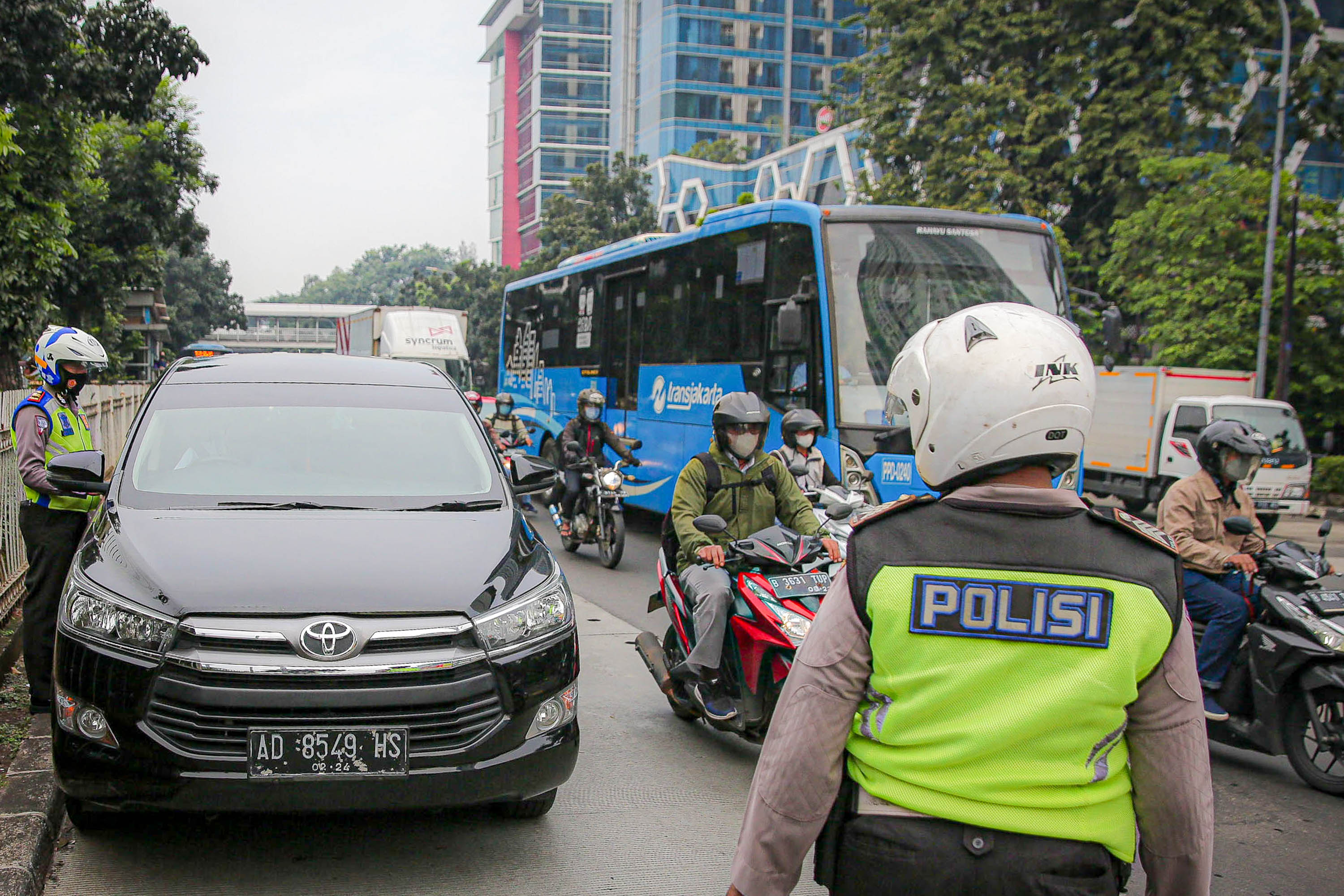 Petugas kepolisian berjaga saat pemberlakuan perluasan kawasan ganjil genap di ruas jalan DI Panjaitan, Cawang, Jakarta, Senin, 6 Juni 2022. Foto: Ismail Pohan/TrenAsia