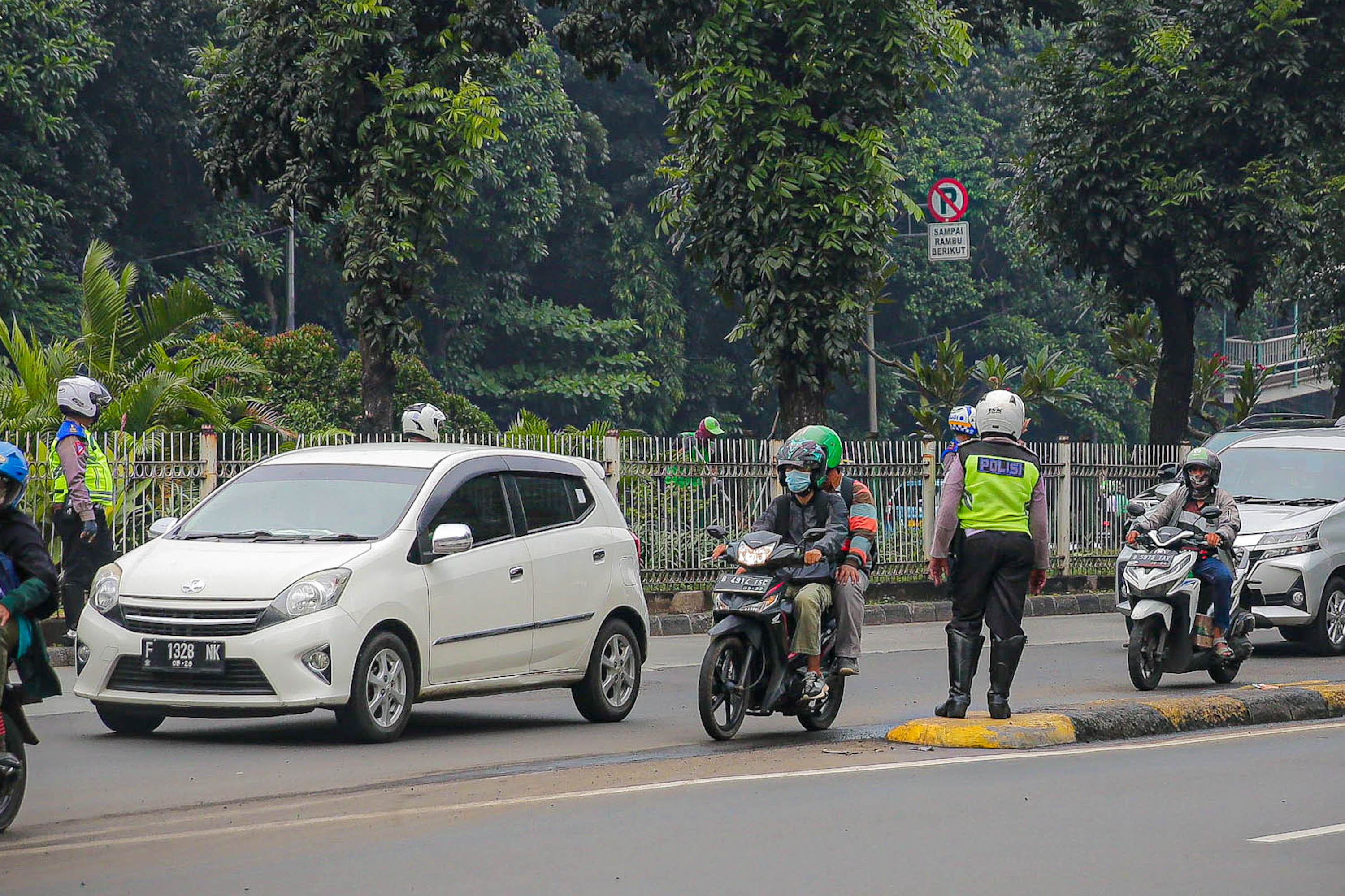 Petugas kepolisian berjaga saat pemberlakuan perluasan kawasan ganjil genap di ruas jalan DI Panjaitan, Cawang, Jakarta, Senin, 6 Juni 2022. Foto: Ismail Pohan/TrenAsia