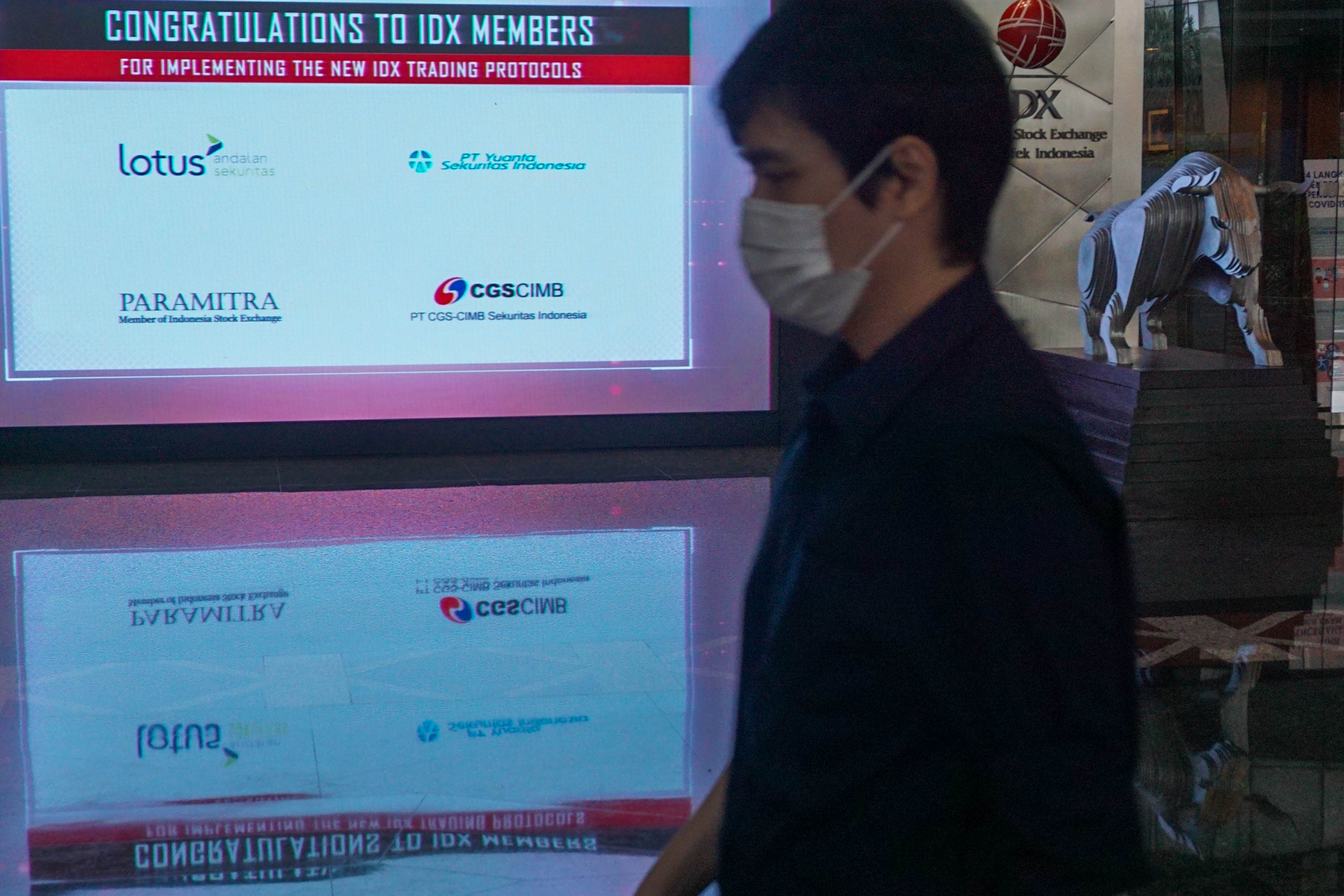 Karyawan melintas di dekat layar daftar perusahaan member IDX yang sudah melantai di Bursa Efek Indonesia (BEI), Jakarta,   Selasa, 7 Juni 2022. Foto: Ismail Pohan/TrenAsia