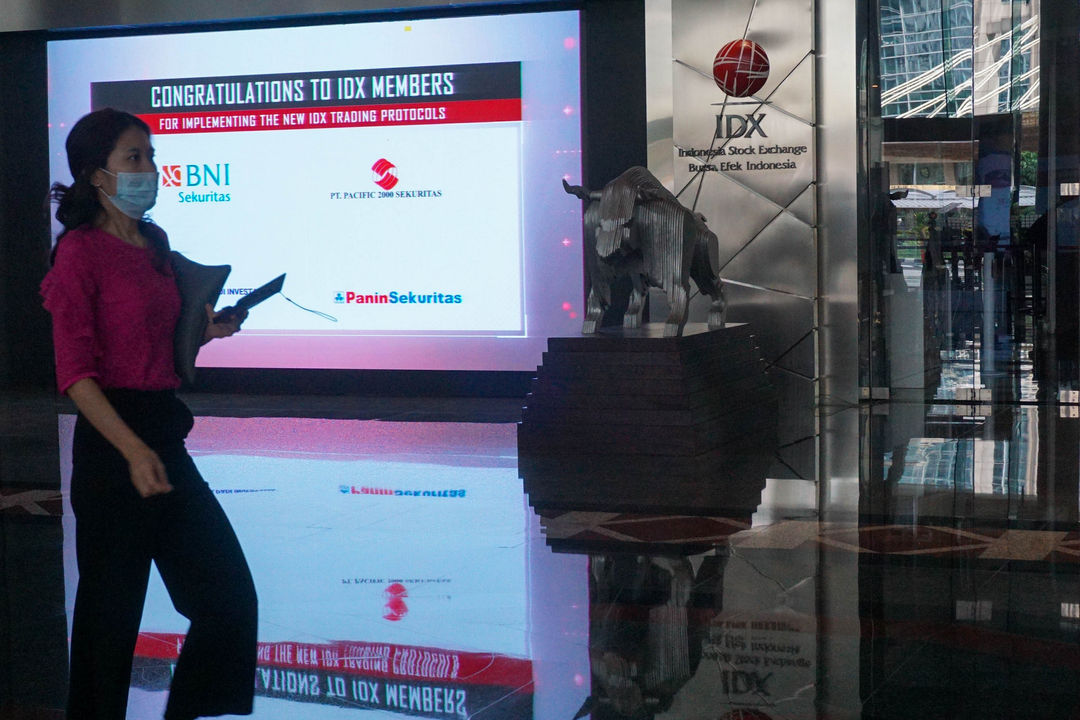 Karyawan melintas di dekat layar daftar perusahaan member IDX yang sudah melantai di Bursa Efek Indonesia (BEI), Jakarta,   Selasa, 7 Juni 2022. Foto: Ismail Pohan/TrenAsia