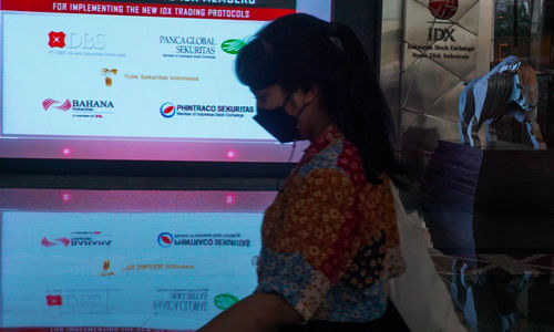 Karyawan melintas di dekat layar daftar perusahaan member IDX yang sudah melantai di Bursa Efek Indonesia (BEI), Jakarta,   Selasa, 7 Juni 2022. Foto: Ismail Pohan/TrenAsia