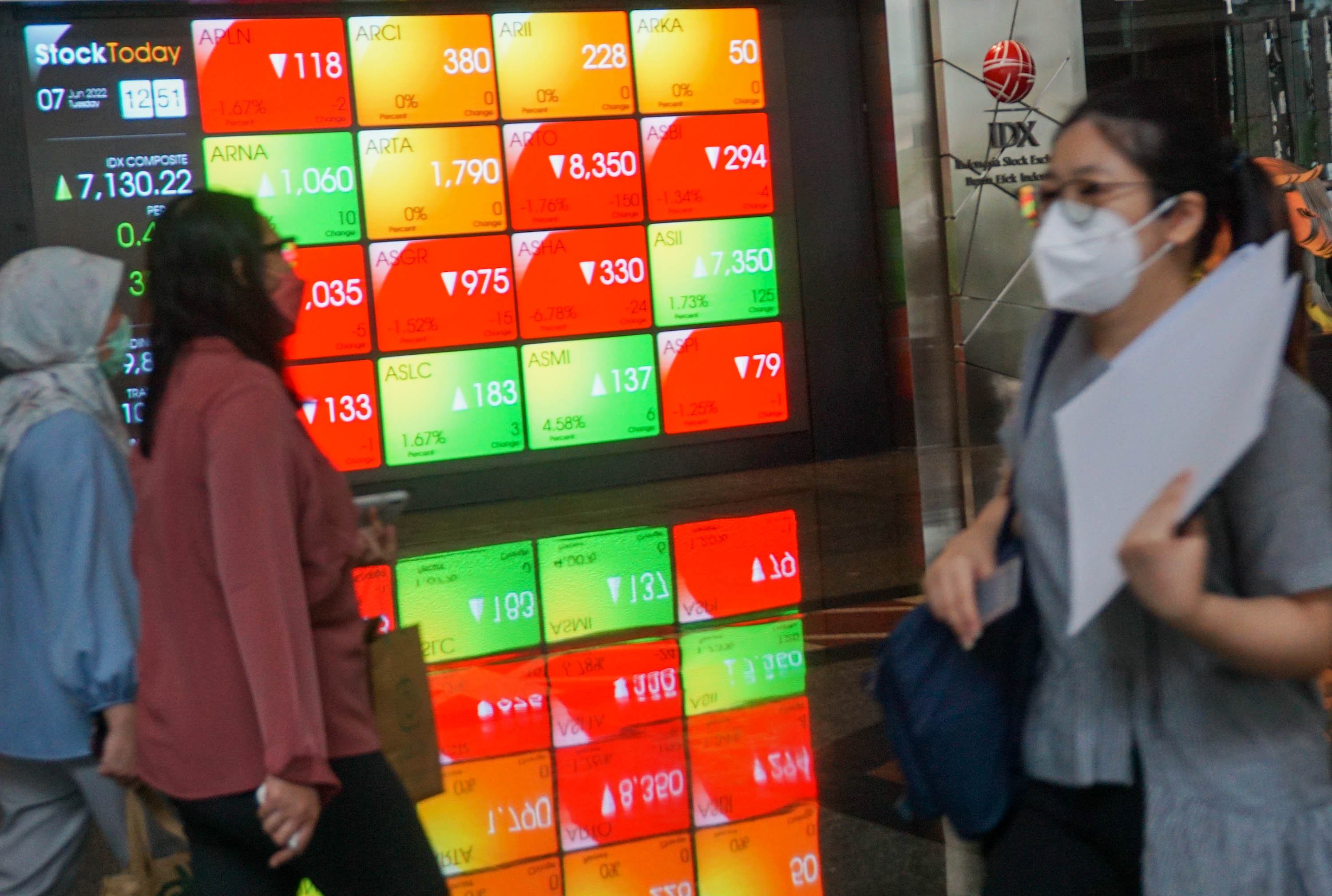 Karyawan melintas di depan layar pergerakan Indeks Harga Saham Gabungan di Gedung Bursa Efek Indonesia (BEI), Jakarta,   Selasa, 7 Juni 2022. Foto: Ismail Pohan/TrenAsia