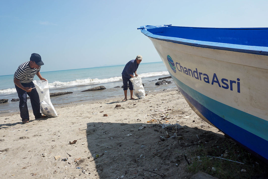 Nelayan mengumpulkan sampah di pesisir pantai Anyer, Cilegon, Banten, Kamis, 30 Juni 2022. Foto: Ismail Pohan/TrenAsia