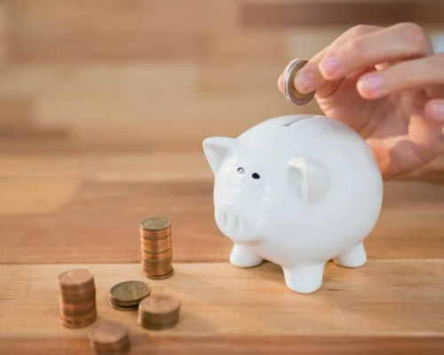 hand-inserting-coin-piggy-bank_1252-1133.webp