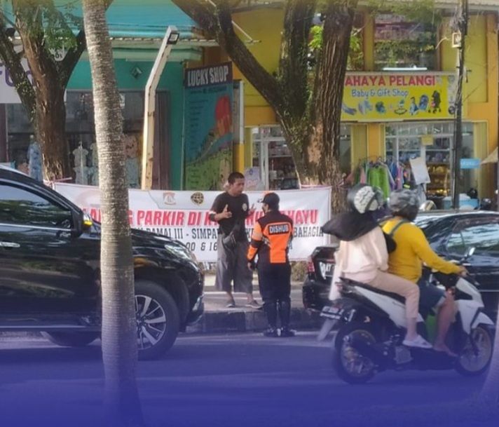 Seorang petugas Dinas Perhubungan menegur pemilik kendaraan di lokasi larangan parkir. Kota Balikpapan dan Samarinda menghadapi tantangan pengelolaan parkir akibat banyaknya parkir liar.