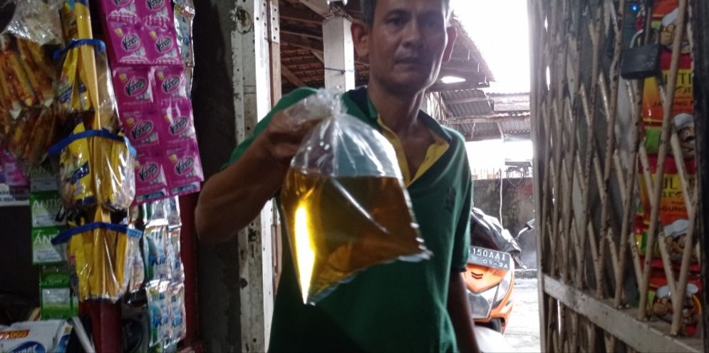 Pedagang menunjukkan minyak goreng kemasan di kiosnya Pasar Senen, Jakarta, Selasa, 31 Mei 2022. Foto: Ismail Pohan/TrenAsia