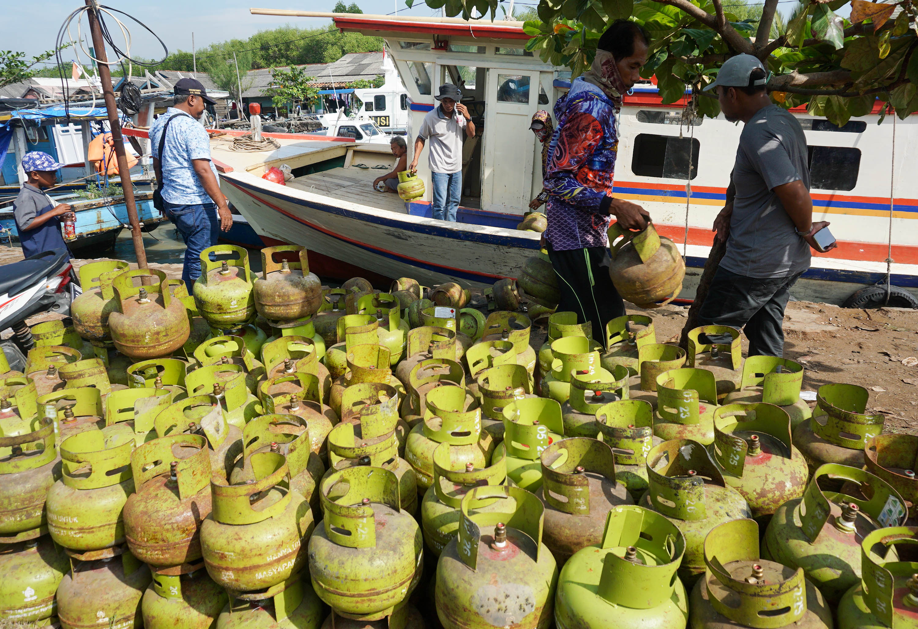 Pekerja melakukan bongkar muat gas elpiji 3 Kg dari kapal nelayan di pelabuhan Karangantu, Serang, Banten. Foto: Ismail Pohan/TrenAsia