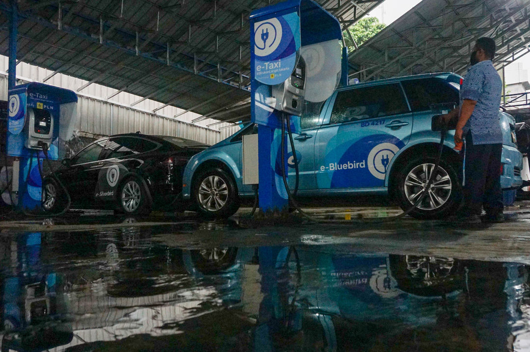 Pengemudi mengisi daya armada taksi listrik Bluebird (e-Taxi) di stasiun pengisian kendaraan listrik  Kantor Pusat Bluebird Group, Mampang Prapatan,  Jakarta, Rabu, 13 Juli 2022. Foto: Ismail Pohan/TrenAsia