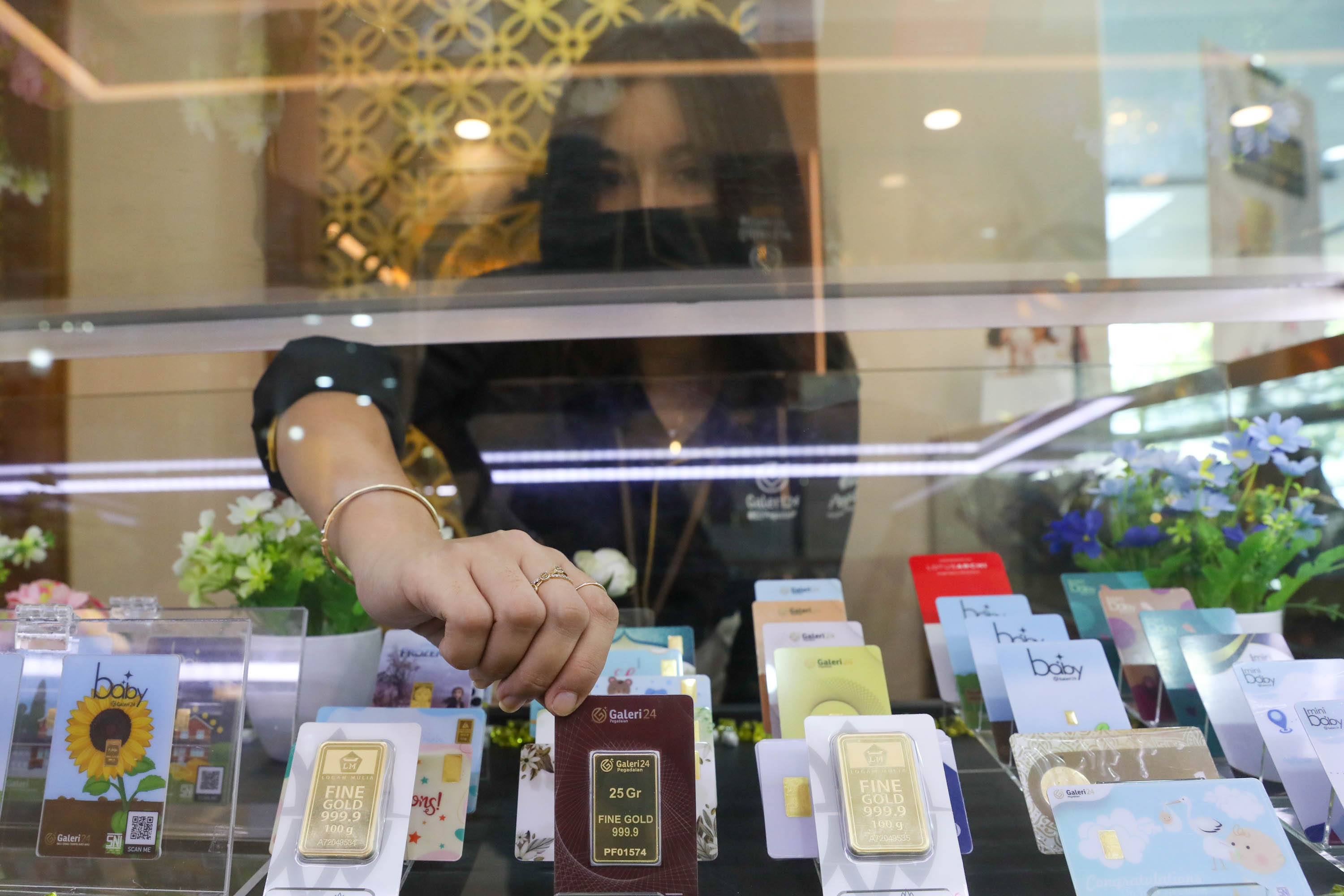 Karyawati menunjukkan emas batangan yang dijual di Galeri 24 Pegadaian, Jakarta, Kamis, 21 Juli 2022. Foto: Ismail Pohan/TrenAsia