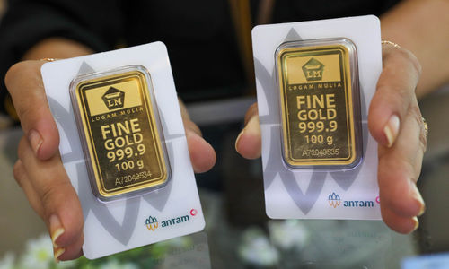 Karyawati menunjukkan emas batangan yang dijual di Galeri 24 Pegadaian, Jakarta, Kamis, 21 Juli 2022. Foto: Ismail Pohan/TrenAsia