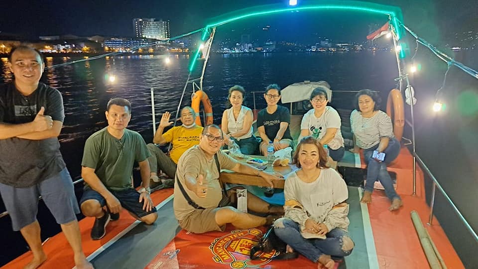 Warga sedang menikmati keindahan laut dan kota pada malam hari dari atas kapal pesiar Manado Bay Sunset Trip. (Foto:Istimewa)