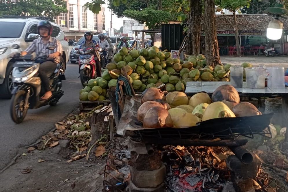 Pengendara melintas di depan salah satu kedai yang menjual dogan bakar