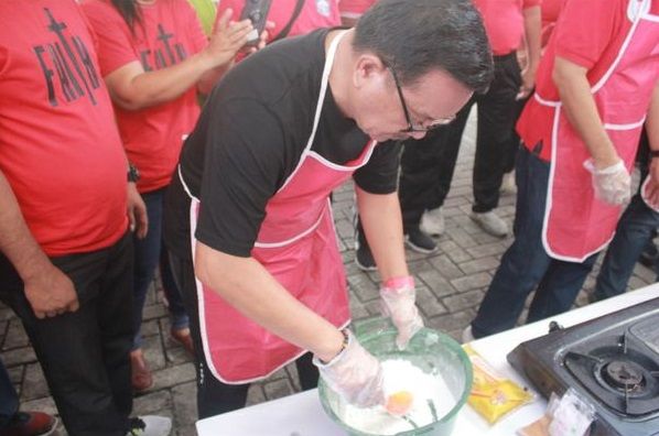 Wali Kota Bitung Maurits Mantiri mengikuti lomba membuat kue cucur. (Foto:Istimewa)