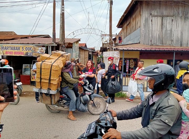 Sekretaris DPC PDI Perjuangan Kota Palembang, Ayu Nur Suri saat membagikan nasi di Palembang, Jumat (23/9)