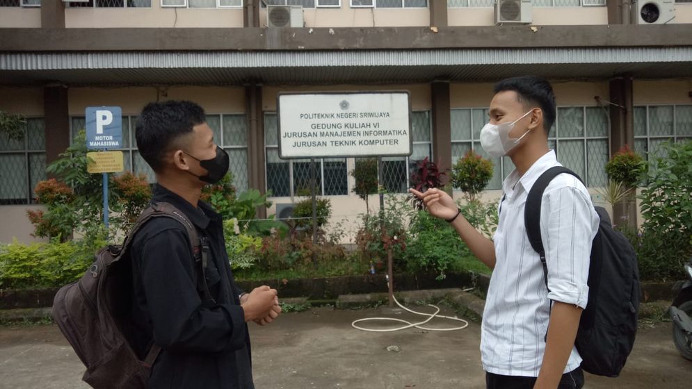 Adhitya (kiri) berbincang dengan teman kampusnya di Polsri Palembang, Senin (31/10).