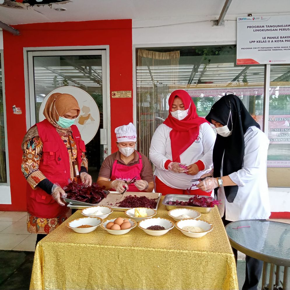 Warga binaan Lapas Perempuan Palembang, Yeni (37) didampingi Kasi kegiatan kerja lapas Perempuan kelas IIA Palembang, Assetia chodijah Tusholiha dan Sr. Spv CSR & SMEPP Pertamina Patra Niaga Sumbagsel, Agustina Mandayati ketika proses pembuatan biskuit sayuran