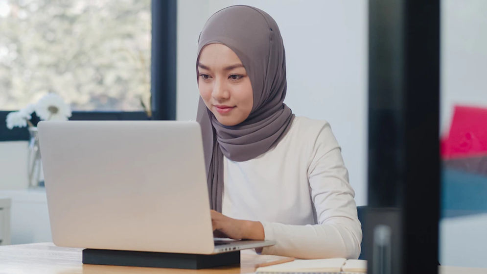 beautiful-asian-muslim-lady-casual-wear-working-using-laptop-modern-new-normal-office_7861-2975.webp