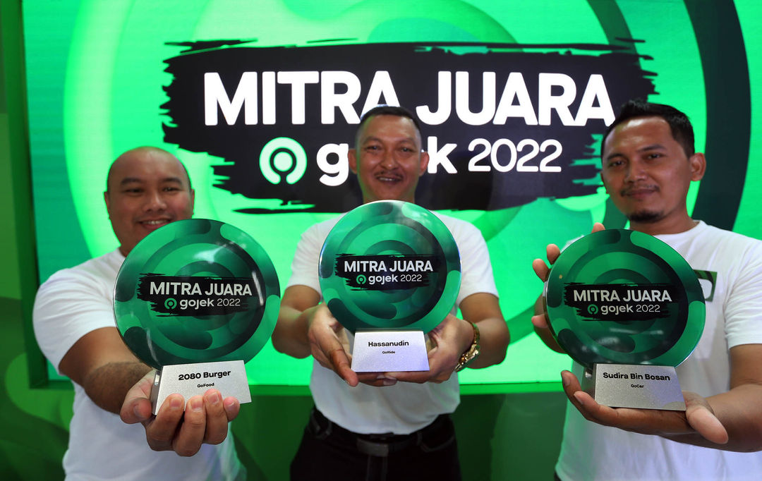 Mitra Juara Gojek kategori GoFood Heru Dwi Soesilo pemilik 2080 Burger - Mitra Juara 2022 untuk kategori GoRide Hassanudin - Mitra Juara Gojek kategori GoCar Sudira menunjukkan plakat Mitra Juara Gojek 2022.Senin 12 Desember 2022. Foto : Panji Asmoro/TrenAsia