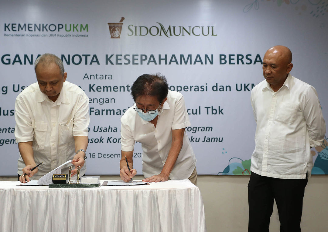 Deputi Bidang Usaha Mikro KemenkopUKM Yulius bersama  Direktur PT Industri Jamu dan Farmasi Sido Muncul Tbk Irwan Hidayat disaksikan KemenkopUKM Teten Masduki saat penandatanganan nota kesepahaman mengenai pemberdayaan usaha mikro melalui program pengembangan rantai pasok komoditas bahan baku jamu di Jakarta,Jumat 17 Desember 2022. Foto : Panji Asmoro/TrenAsia