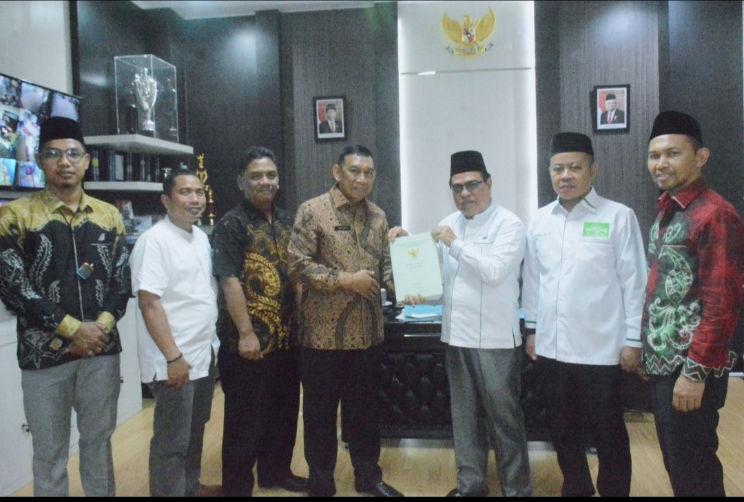 Kepala ATR/BPN Kota Banjarmasin menyerahkan SHM Aset milik PWNU Kalsel yang terletak di jalan Hasanuddin HM. (Foto : Dokumentasi PWNU Kalsel)