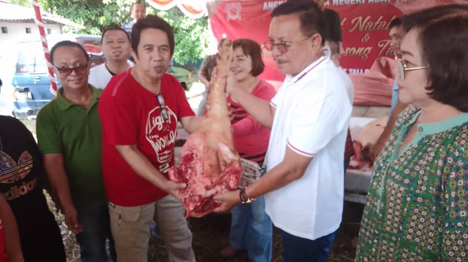 Wali Kota Maurits Mantiri didampingi Ketua Tim Penggerak PKK Kota Bitung menyerahkan daging gratis jelang Natal. (Foto:Istimewa)