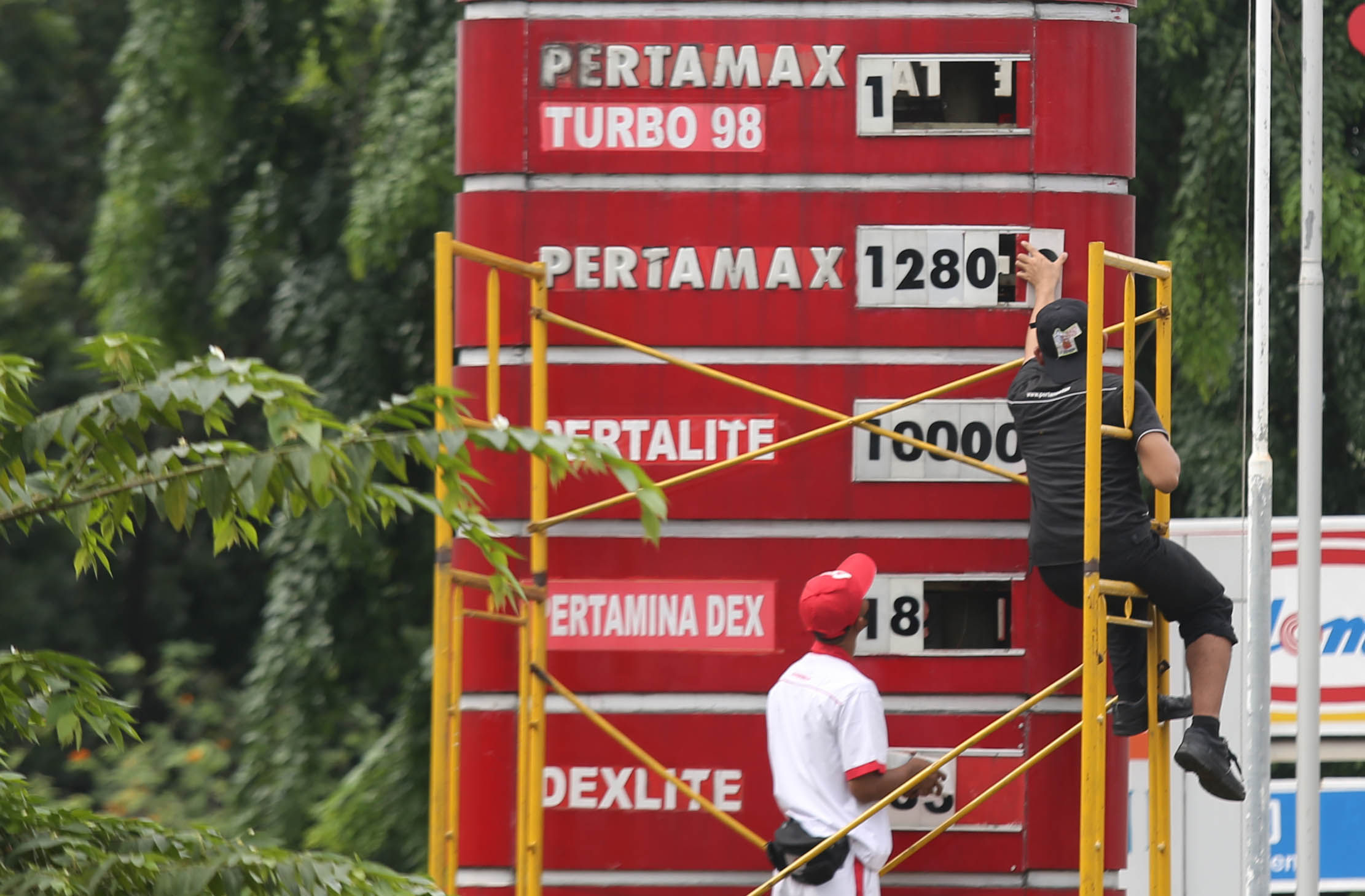 Petugas tengah mengganti papan harga BBM di sebuah SPBU kawasan Kebun Jeruk Jakarta Barat. PT Pertamina hari ini 3 Januari 2023 pukul 14.00 menurunkan harga Pertamax,Pertamax Turbo dan Pertamina Dex. Foto : Panji Asmoro/TrenAsia