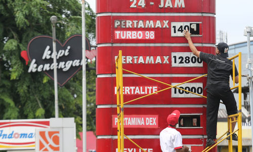 Petugas tengah mengganti papan harga BBM di sebuah SPBU kawasan Kebun Jeruk Jakarta Barat. PT Pertamina hari ini 3 Januari 2023 pukul 14.00 menurunkan harga Pertamax,Pertamax Turbo dan Pertamina Dex. Foto : Panji Asmoro/TrenAsia