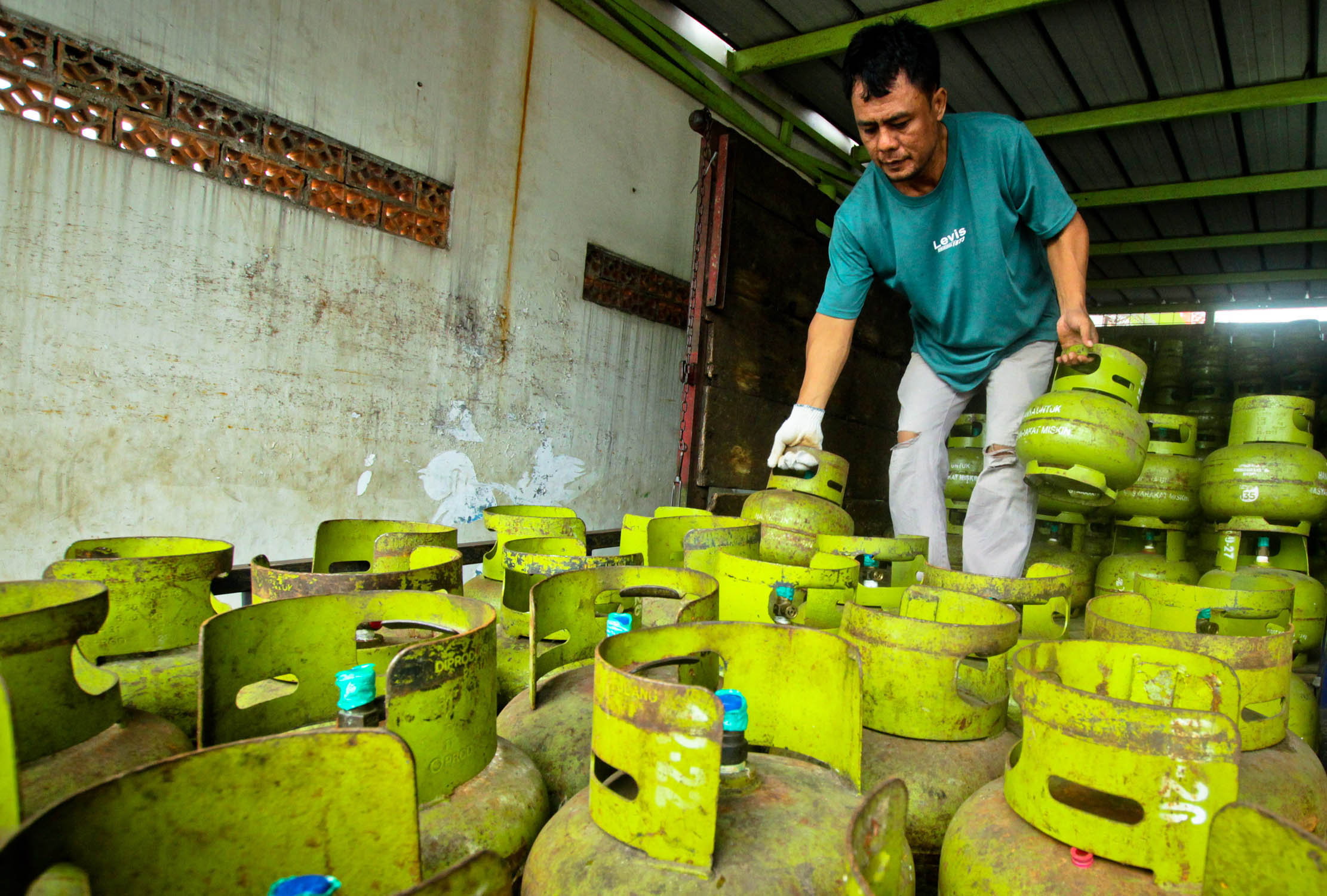 Nampak penjual tengah merapikan susunan tabung gas LPG 3Kg di sebuah agen gas kawasan Cipondoh Kota Tangerang.Kamis 5 Januari 2022. Foto : Panji Asmoro/TrenAsia
