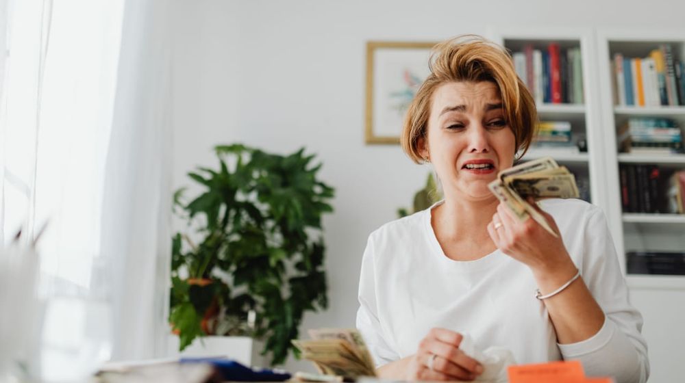 Photo by Karolina Grabowska: https://www.pexels.com/photo/woman-counting-money-and-paying-bills-with-sadness-5900157/