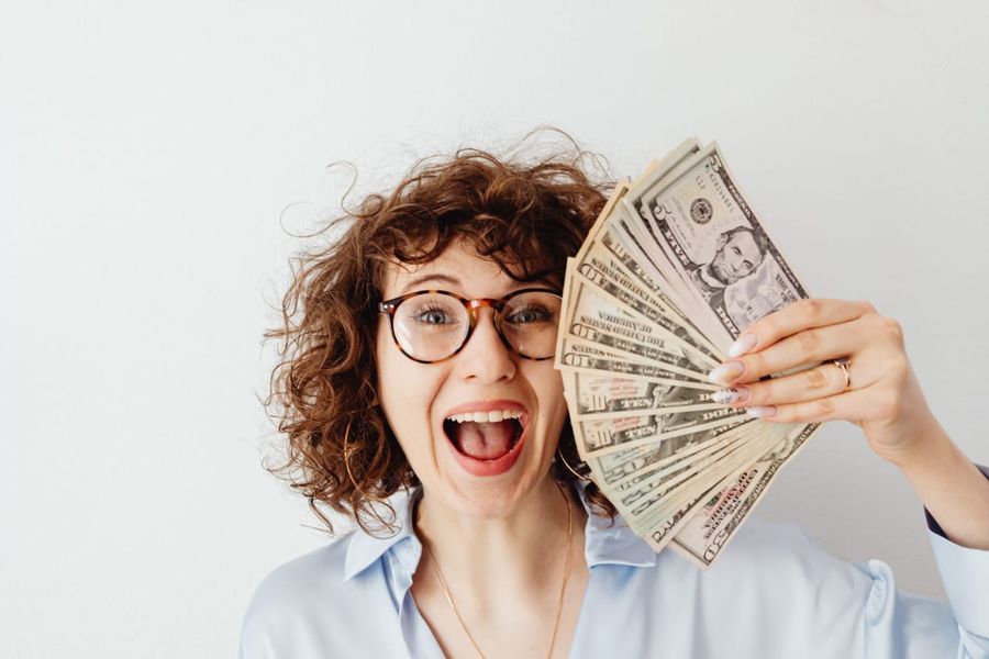 Photo by Karolina Grabowska: https://www.pexels.com/photo/happy-woman-in-blue-long-sleeve-blouse-holding-money-7680637/