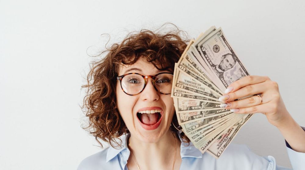 Photo by Karolina Grabowska: https://www.pexels.com/photo/happy-woman-in-blue-long-sleeve-blouse-holding-money-7680637/