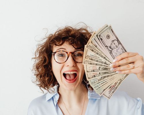 Photo by Karolina Grabowska: https://www.pexels.com/photo/happy-woman-in-blue-long-sleeve-blouse-holding-money-7680637/