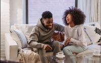 Photo by Andres  Ayrton: https://www.pexels.com/photo/expressive-young-black-couple-having-fun-at-couch-at-home-6579046/