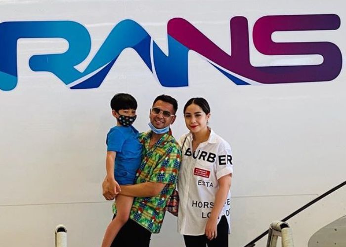 Raffi Ahmad bersama keluarga berfoto di depan logo RANS Entertainment yang terpampang di badan pesawat maskapai Garuda Indonesia, 30 Agustus 2020.