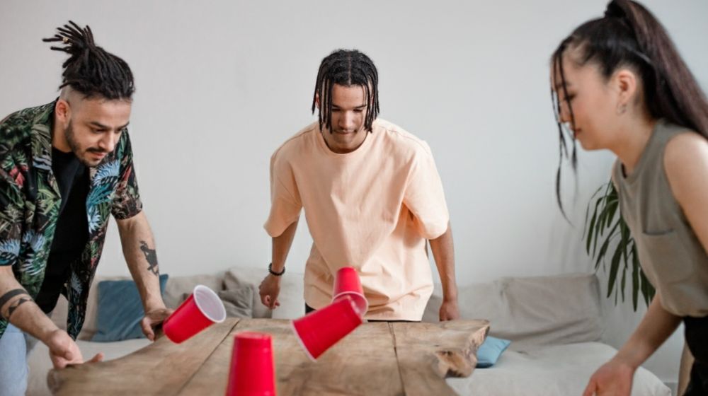 Photo by Ron Lach : https://www.pexels.com/photo/group-of-friends-playing-using-red-plastic-cups-8368342/