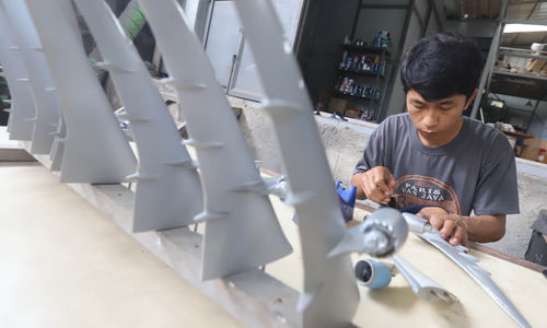 Nampak pekerja tengah menyelesaikan pembuatan miniatur pesawat dan helikopter di kawasan Cibinong, Jawa Barat, Minggu 12 Februari 2023. Foto : Panji Asmoro/TrenAsia