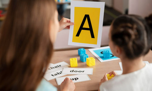 psychologist-helping-little-girl-speech-therapy-indoors.jpg