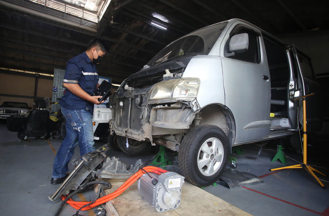 Mekanik mengkonversi kendaraaan niagal berbahan bakar minyak menjadi mobil listrik di salah satu bengkel mobil di kawasan Lengkong Wetan Tangerang Selatan, Banten, Selasa, 7 Maret 2023. Foto : Panji Asmoro/TrenAsia