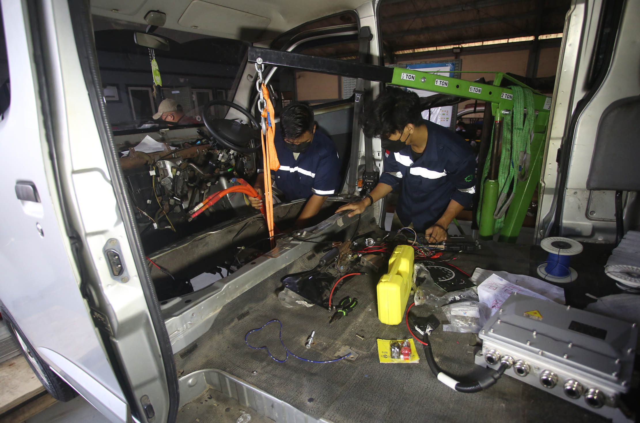 Mekanik mengkonversi kendaraaan niagal berbahan bakar minyak menjadi mobil listrik di salah satu bengkel mobil di kawasan Lengkong Wetan Tangerang Selatan, Banten, Selasa, 7 Maret 2023. Foto : Panji Asmoro/TrenAsia