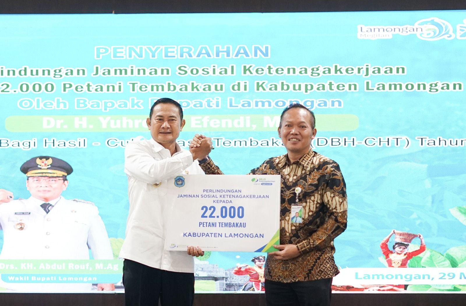 Kepala Kantor Wilayah Jawa Timur BPJS Ketenagakerjaan Hadi Purnomo (kanan) menyerahkan bukti kepesertaan 22 ribu petani tembakau secara simbolis pada Bupati Lamongan Yuhronur Efendi, Rabu (29/3/2023) di Pendopo Lokatantra.