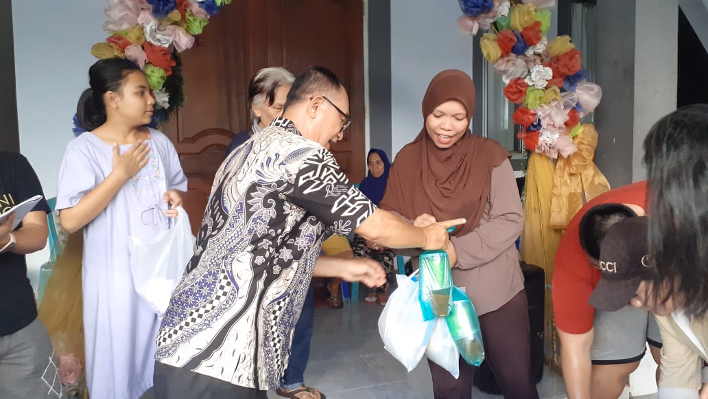 Pendeta Jen Henry Woy,M.PTh selaku Pendeta Gereja Masehi Advent Hari Ketujuh Jemaat Tumou Tou saat membagikan takjil dan beras gratis kepada warga Muslim. (Foto:Mike)