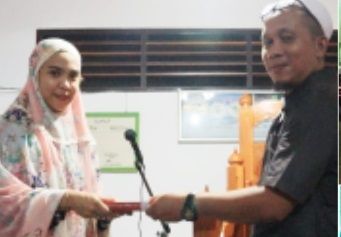 Ketua KNPI Bolmong, Feramitha Tiffani Mokodompit menyerahakn bantuan Al-Qur'an dalam kegiatan safari Ramadhan. (Foto:Istimewa)